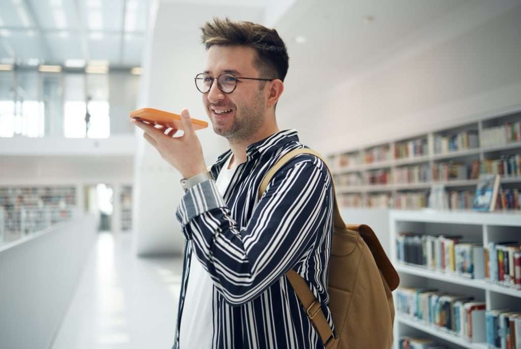 Man, phone call and speaker in library, smile and connection for communication, talking and plannin